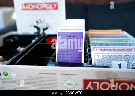 Monopol board Eigenschaften und Geld ordentlich in den Banking Fach gestapelt während eines Spiels auf der 80th Anniversary Edition brettspiel Stockfoto