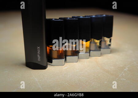 Smok Infinix nachfüllbar Pod vape pen Elektronische Zigarette mit Hülsen mit e-Säfte mit verschiedenen Schattierungen von Orange in einem Farbverlauf angeordnet, isolieren Stockfoto