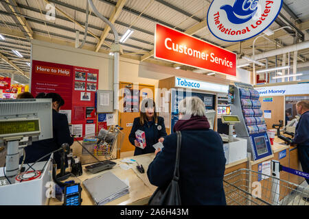 Die Customer Service Desk bei Tesco Express im Longton, Kunden mit verschiedenen Problemen und Beschwerden dienen Stockfoto