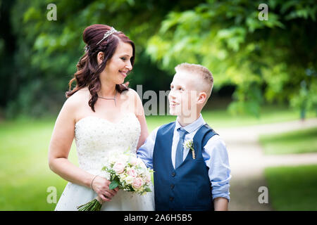 Ein schönes Lächeln verlegen Sohn sieht sich als Mutter schön lächelt ihn an Ihrem Hochzeitstag, Mutter und Sohn Stockfoto