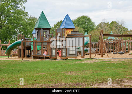 Kinder spielen auf einem großen Spielplatz in einem öffentlichen Park in Montgomery Alabama, USA. Stockfoto