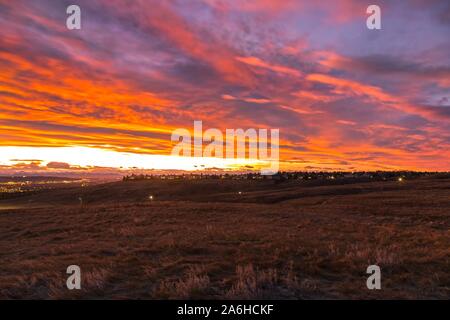 Dramatischer Abend brennender Himmel und Sonnenuntergang Sonnenlicht reflektiert Chinook Wolken Landschaft aus Nose Hill Urban Prärie Naturpark in Calgary, Alberta Stockfoto