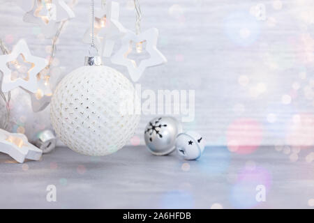 Neues Jahr Dekorationen auf Holz- Hintergrund. lichtgirlanden in Form von Sternen und Glaskugeln mit Jingle bells für Weihnachten Home Decor Stockfoto