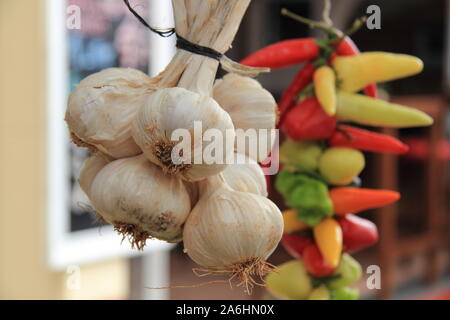 Ein Knoblauch Geflecht und Peperonis auf einem Markt Stockfoto