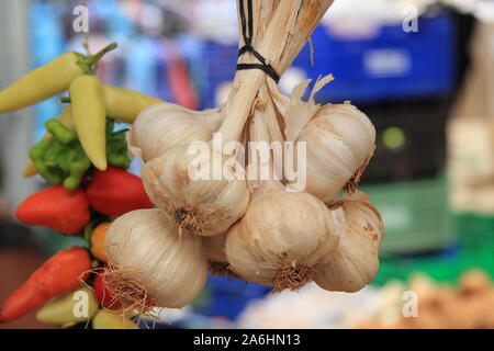 Ein Knoblauch Geflecht und Peperonis auf einem Markt Stockfoto