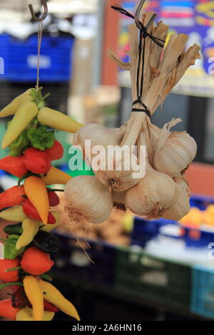 Ein Knoblauch Geflecht und Peperonis auf einem Markt Stockfoto