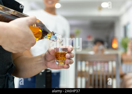 Hand gießen Starke alkoholische Getränke in Gläsern erschossen. Stockfoto