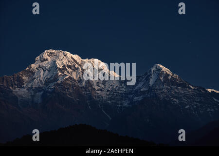 Snowy Annapurna und Hinchuli Berge an dunklen blauen Himmel bei Sonnenaufgang in Nepal Stockfoto