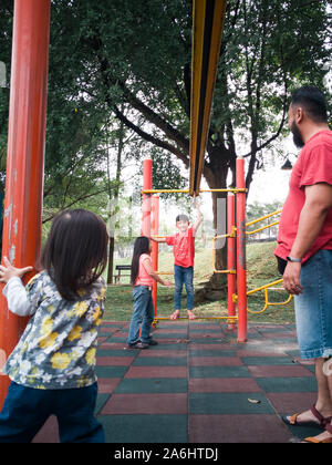 Asiatische Familie spielen in der Monkey Bar Spielplatz am Morgen. Stockfoto