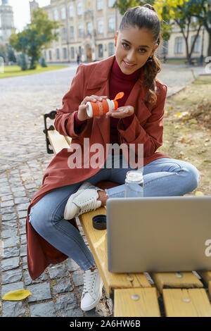 Lächelnden jungen Frau, die bereit ist, Ihr probiotika zu nehmen Stockfoto