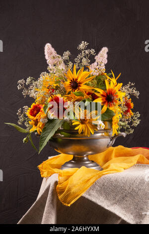 Stillleben mit hellen Blumen auf einem dunklen Hintergrund Stockfoto