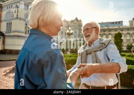 Leben verbringen, mit Leuten, die Sie glücklich machen. Schöne und fröhliche senior Paar tanzen zusammen im Freien an einem sonnigen Tag Stockfoto