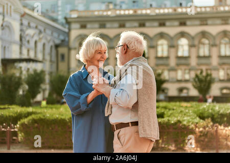 Für immer zusammen. Gerne älteres Paar tanzen und lächelnd, während man im Freien Stockfoto