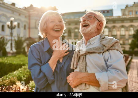 Sie machen mich glücklich! Portrait von Schöne und stilvolle Senior lachen während im Park zusammen an einem sonnigen Tag Stockfoto
