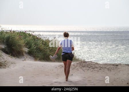 Junge Frau durch die Dünen an der Nordsee wird am Strand in der Nähe von Hvide Sande, Dänemark am 27. Juli 2019 © Michal Fludra/Alamy Live Nachrichten gesehen Stockfoto