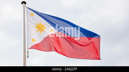 Philippinen Flagge. Philippinen nationale Zeichen und Symbol winken auf einem Fahnenmast gegen bewölkter Himmel Hintergrund Stockfoto