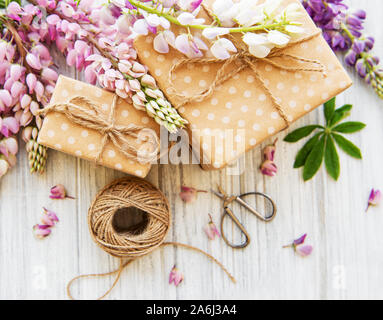 Lupine Blumen auf weißem Hintergrund und Geschenkboxen aus Holz Stockfoto