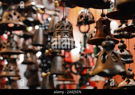 Unscharfer Hintergrund mit dekorativen handgefertigte Keramik Glocken auf dem Stand des Weihnachtsmarkt angezeigt, Thema der Holiday Shopping Stockfoto