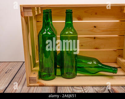 Leere Weinflaschen in einer Holzkiste auf dem Tisch. Home Weinbereitung Stockfoto