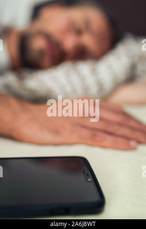Foto von einem gutaussehenden jungen Mann und sein Telefon im Hintergrund Stockfoto
