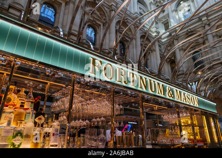 Freizeitaktivitäten in der Stadt nach Arbeit: Gut sortierte Fortnum & Mason Weinbar mit beleuchteten Zeichen und Namen innerhalb der Royal Exchange, London EC3, VEREINIGTES KÖNIGREICH Stockfoto