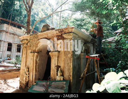 Restaurierungsarbeiten durchgeführt, die von einem Arbeiter auf verborgenen Dschungel Tempel von Wat Pha Lat in Chiang Mai, Thailand. Stockfoto