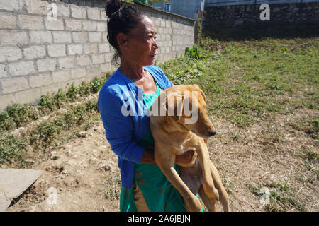 Kathmandu, Nepal. 27 Okt, 2019. Eine Frau trägt ein Hund während des Festival. Kukur Tihar oder Kukur Puja bedeutet wörtlich die Anbetung der Hunde. Dies ist ein Mini-Festival innerhalb eines größeren Hindu Feier von Diwali, das Festival der Lichter. Nach nepalesischer Tradition, einer der festlichen Tage ist ausschließlich für die meisten gewidmet der menschlichen Freund und Wächter gewidmet. In der hinduistischen Religion, ein Hund ist ein heiliges Tier, die eine besondere Bindung an einen Menschen zu haben, um uns auf unserem Weg in den Himmel zu begleiten. Credit: SOPA Images Limited/Alamy leben Nachrichten Stockfoto