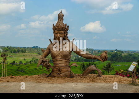 Statue von Dewi Sri, die Göttin der Reis, getrockneten Reis pflanze Blätter gemacht, in der Mitte von Terrassen Jatiluwih, ein UNESCO-Weltkulturerbe Im entfernt Stockfoto