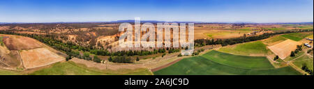 Ufer des Hunter River in Hunter Valley bei Dürre - Grün bewässerten Feldern gegen trockenen trockenen Boden der Outback in weiten Panorama über Antenne. Stockfoto