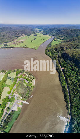 Wicklung schlammigen Hawkesbury River um Wisemans Ferry Stadt zwischen Bergketten in der Nähe von Sydney in Australien. Delta von Macdonald Fluss fließen zu t Stockfoto