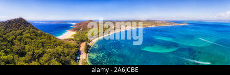 Port Stephens Küste Shoal Bay Town Waterfront mit Mt Tomaree und Zenith Strand in weiten Antenne Panorama über der Wasseroberfläche in Australien an einem sonnigen Tag. Stockfoto