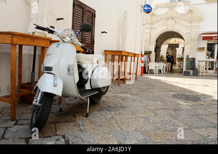 Gallipoli, Apulien, Italien - Juni 28, 2019: Weiß scooter Vespa Piaggio auf der Straße in der Innenstadt von Weißen Stadt Gallipoli, Salento Apulien in Süditalien. Stockfoto