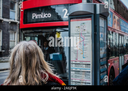 Ansicht der Rückseite des blonde Frau an der Bushaltestelle warten auf einen Bus Stockfoto