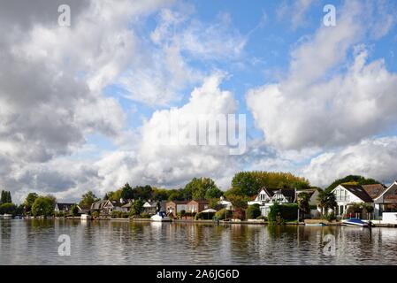 Waterside private Häuser am Flussufer in Sunbury on Thames gegen einen dramatischen Wolkenbildung, Surrey, England, Großbritannien Stockfoto