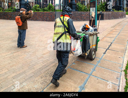 Streetcleaner am Kings Cross mit einem männlichen Touristen, der fotografiert Im Hintergrund Stockfoto