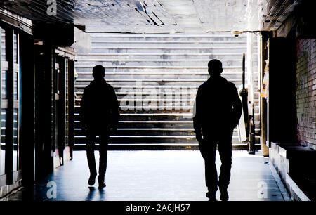 Zwei Männer zu Fuß in der Nähe der U-Bahn Gehweg Passage in hoher Kontrast schwarz und weiß Stockfoto