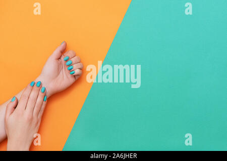 Perfekte Maniküre mit trendy Nailart auf orange und grün Hintergrund mit kopieren. Stockfoto