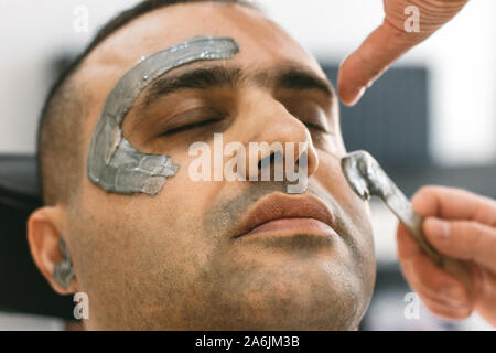 Männliche Gesicht wachsen. Friseur Haare durch shugaring vom Gesicht des türkischen Mannes. Stockfoto