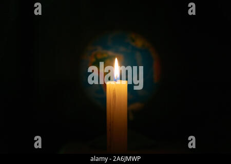 Globus mit Kerzen beleuchtet. Konzept der globalen Erwärmung oder der Earth Hour. Soft Focus Stockfoto