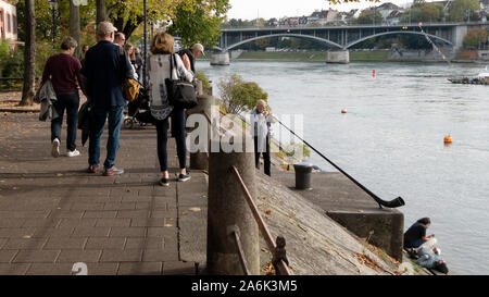 Passanten an der Rheinpromenade hören die Musik eines Alphorns Musiker. Stockfoto