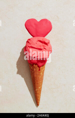 Erdbeereis mit Waffel Kegel schmelzen auf dem Boden in Liebe Herz Form. Eis Liebe Stockfoto