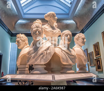 Eine Gruppe von Regency/Georgische/viktorianischen Marmorbüsten oder Skulpturen, die National Portrait Gallery, London, UK - dargestellt in dramatischen, Beleuchtung