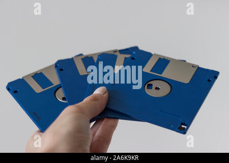 Holding blaue Diskette ein Festplatten auf weißem Hintergrund. Disk Storage Stockfoto