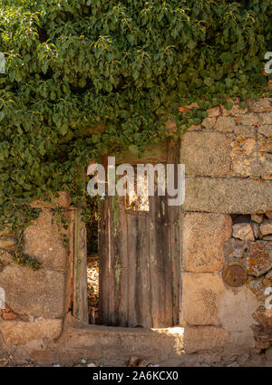 Hölzerne Tür öffnen in Garten von Haus aus Stein in der antiken Stadt Castelo Rodrigo in Portugal Stockfoto