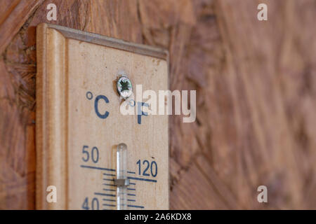 Wärme Temperatur Thermometer auf der hölzernen Wand außerhalb des Hauses Stockfoto