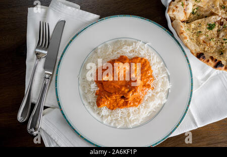 Chicken Tikka Masala mit Knoblauch Naan Brot auf weiße Platte auf Serviette und von oben genommen Stockfoto