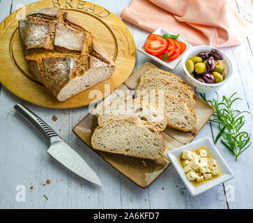 Scheiben von sauerteigbrot zusammen mit Feta Käse, schwarze und grüne Oliven und Tomaten. Stockfoto