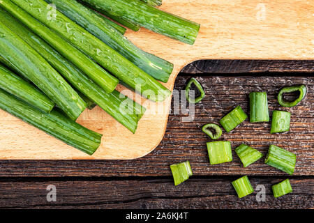 Bündel grüne Zwiebeln auf Tisch. In Scheiben geschnittene Zwiebel zum Kochen Salat in der Küche Stockfoto