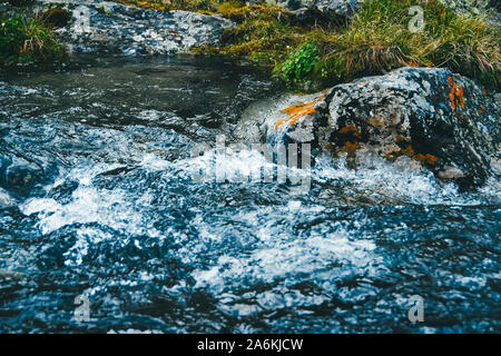 Starke mountain river. Schnelle Informationsfluss stream unter den Felsen. Blue Stream von Wasser brodelt in den Felsen, Stockfoto