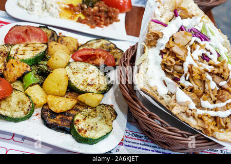 Barcelona Spanien, Catalonia Gracia, Nachbarschaft, Zurna, Restaurant, Halal, innen, Esstisch, gegrilltes Gemüse, Zucchini, Tomaten, Kartoffeln, Huhn Gyro san Stockfoto